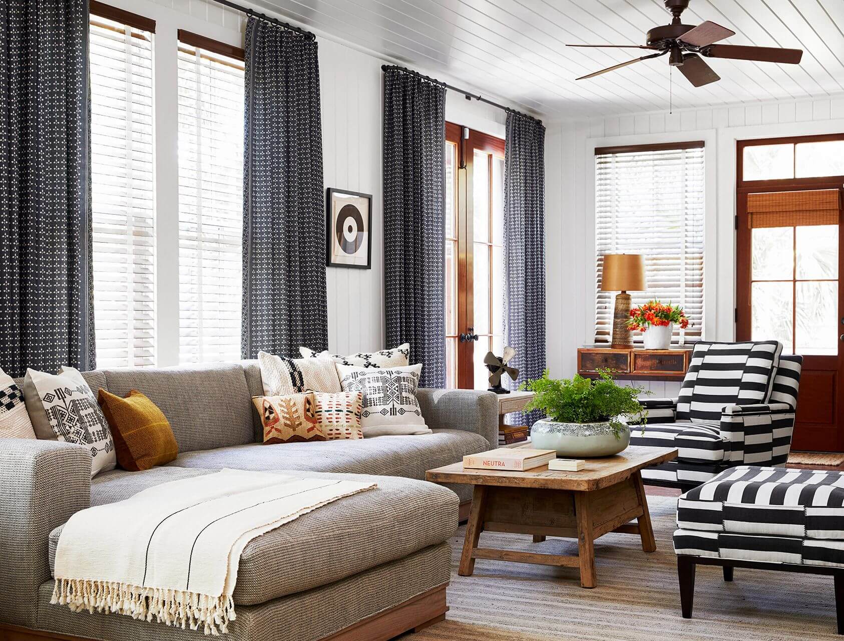 A beautifully decorated modern living room with elegant window blinds letting in soft light.
