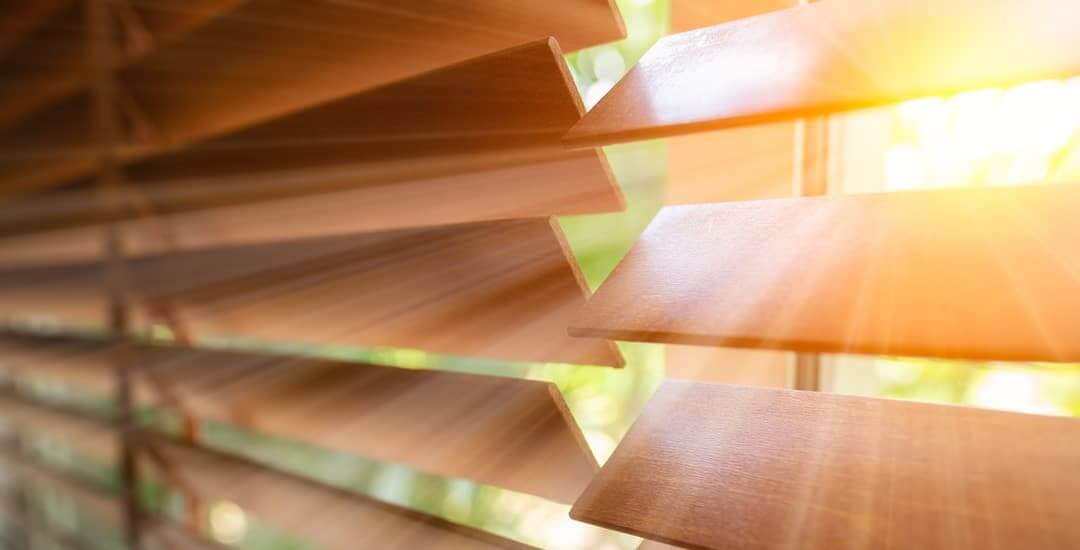 Classic wood venetian blinds filtering sunlight.