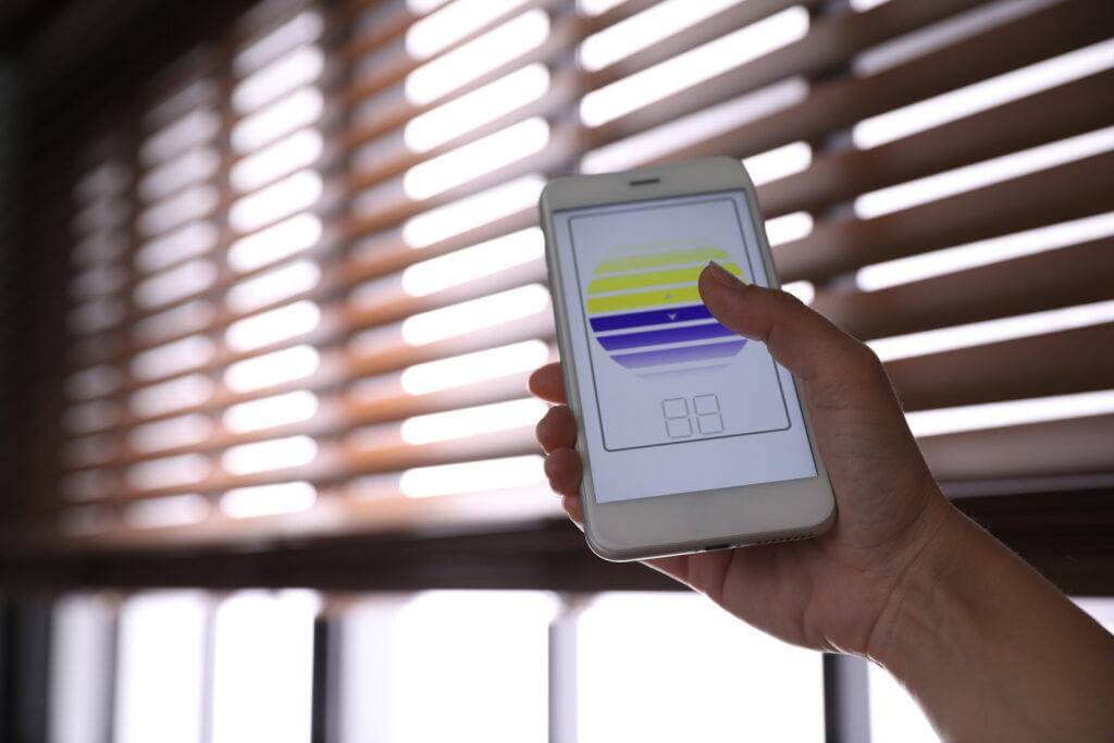A person controlling their smart blinds with a smartphone.